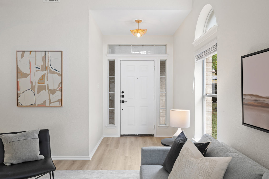 1305 Tudor House Road Pflugerville, TX 78660 - Photo 9 of 40 A light filled entry with tall ceilings and graceful arched windows sets the tone for the thoughtful design found throughout the home.