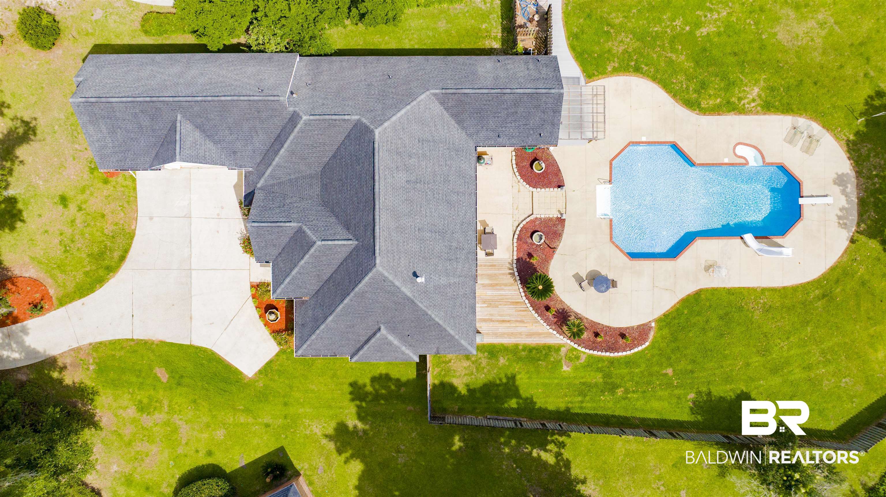 8847 Dawes Lake Road South Mobile, AL 36619 - Photo 44 of 47 Expansive rear patio featuring a freeform pool, concrete decking, and landscaped beds