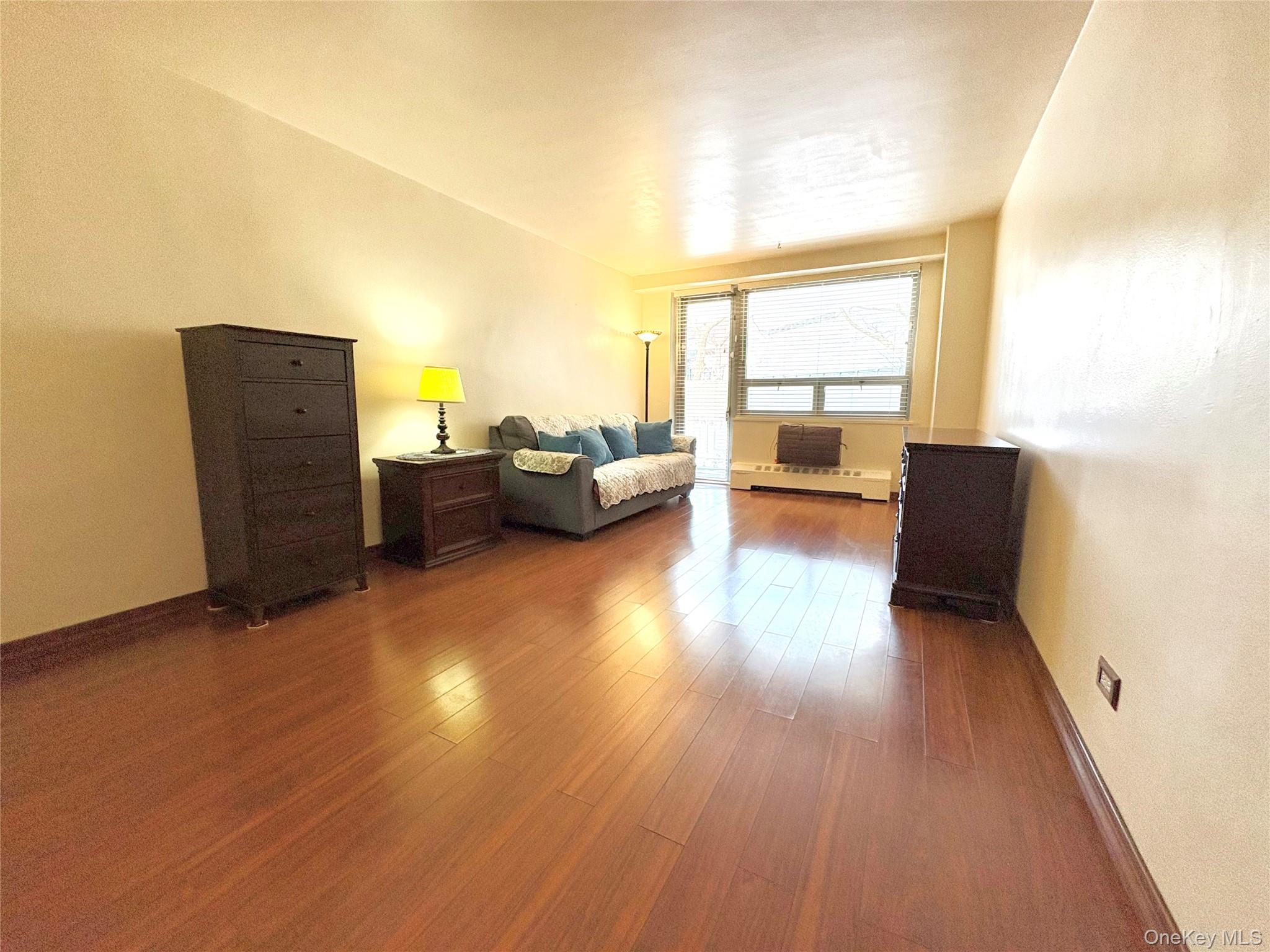 61-15 97th Street, Unit LC Queens, NY 11374 - Photo 11 of 27 a living room with furniture and a large window