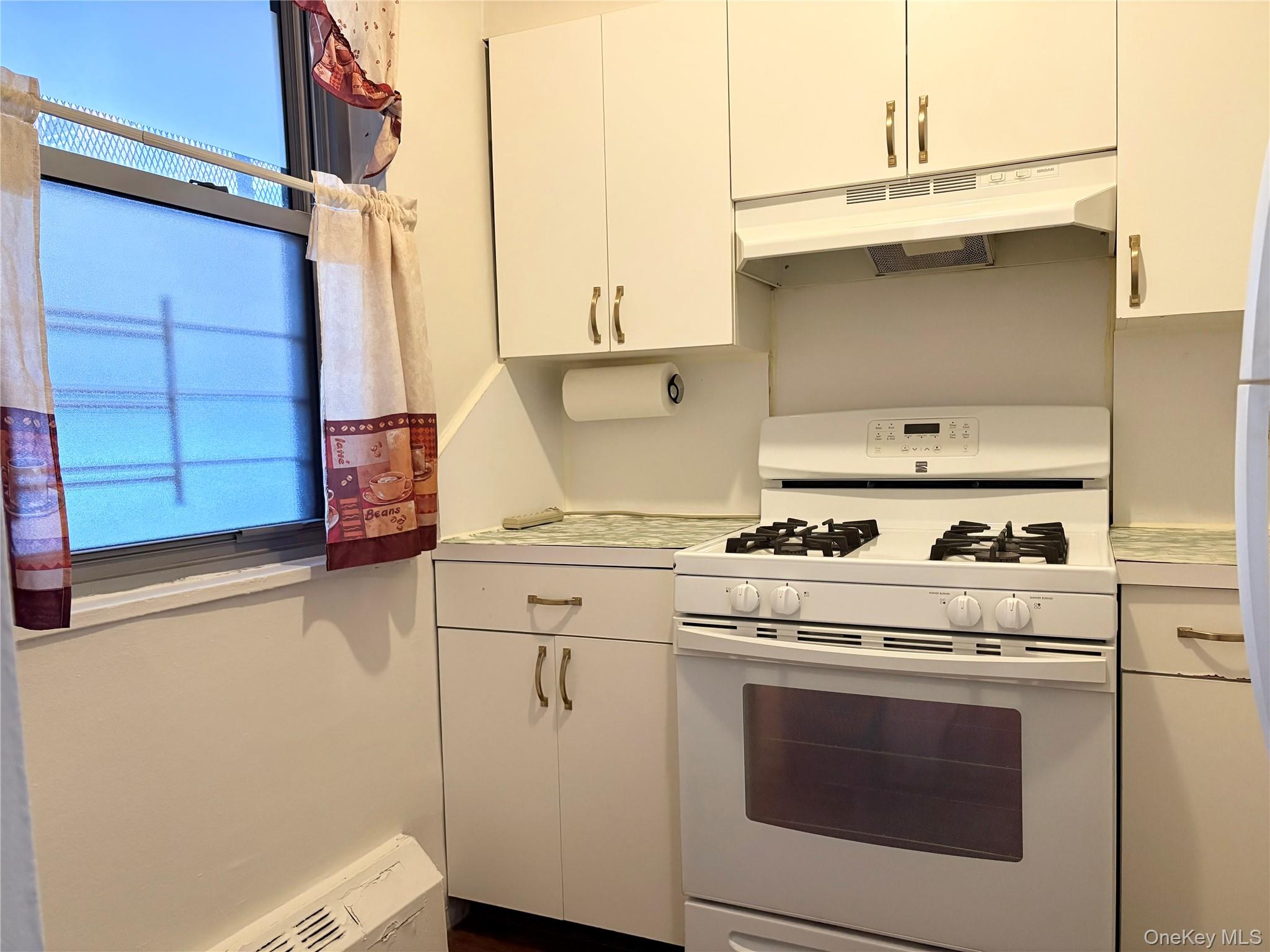 61-15 97th Street, Unit LC Queens, NY 11374 - Photo 4 of 27 a kitchen with a stove and a white cabinets