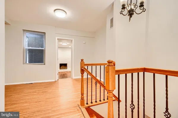 a view of a hallway with wooden floor and staircase