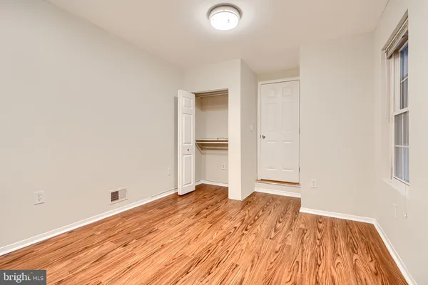 a view of a room with wooden floor and a ceiling fan