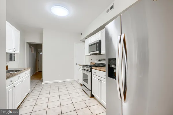 a kitchen with stainless steel appliances a refrigerator sink and microwave
