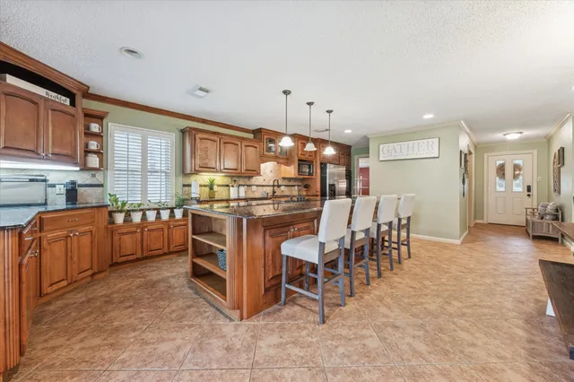 a large kitchen with stainless steel appliances granite countertop a sink and counter space