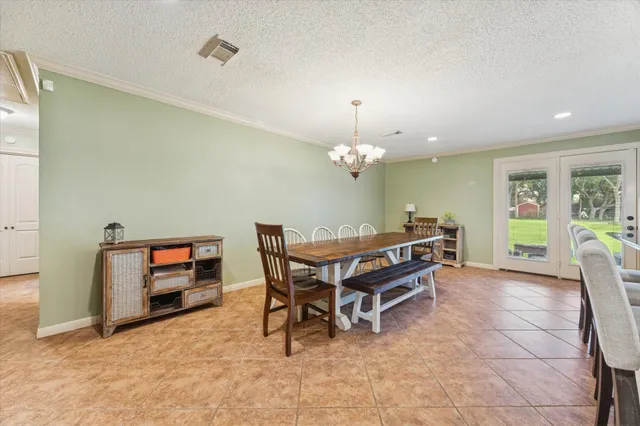 a kitchen with stainless steel appliances kitchen island granite countertop a table chairs and a refrigerator