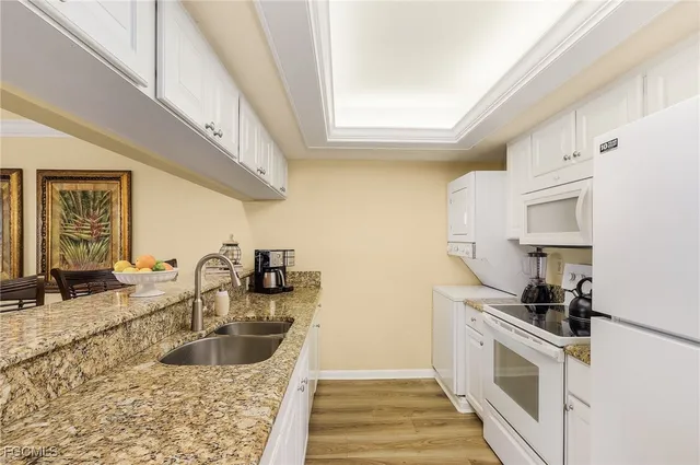 a kitchen with granite countertop a sink and a stove top oven
