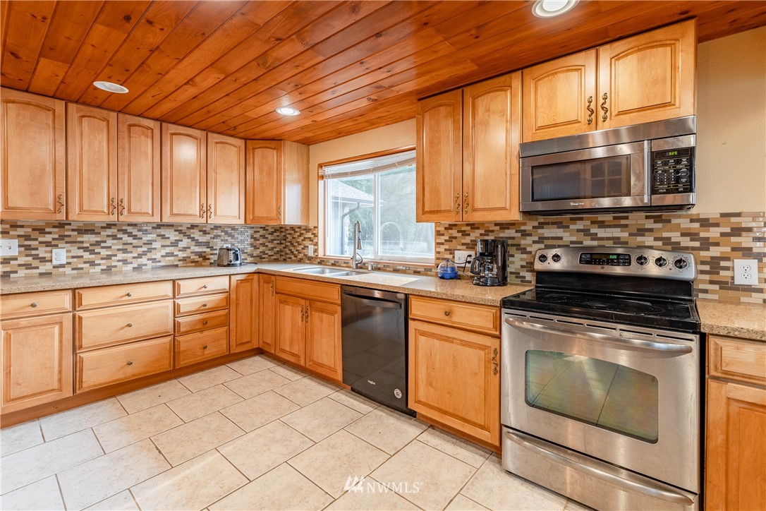 3826 Sapp Road Southwest Olympia, WA 98512 - Photo 11 of 39 a kitchen with stainless steel appliances granite countertop a stove a sink and a microwave
