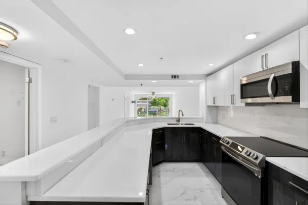 a kitchen with a sink a microwave and cabinets