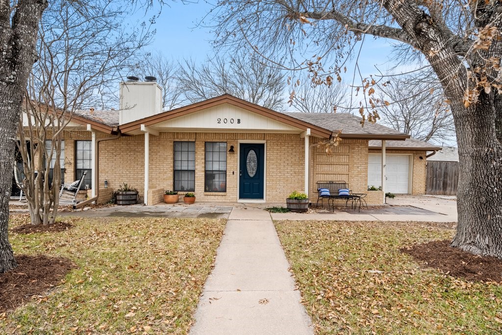200 South Mockingbird Lane, Unit B Lockhart, TX 78644 - Photo 1 of 15 a front view of a house with a yard and garage