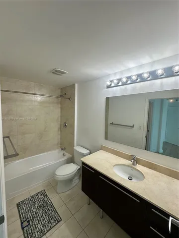 a bathroom with a double vanity sink toilet mirror and bathtub