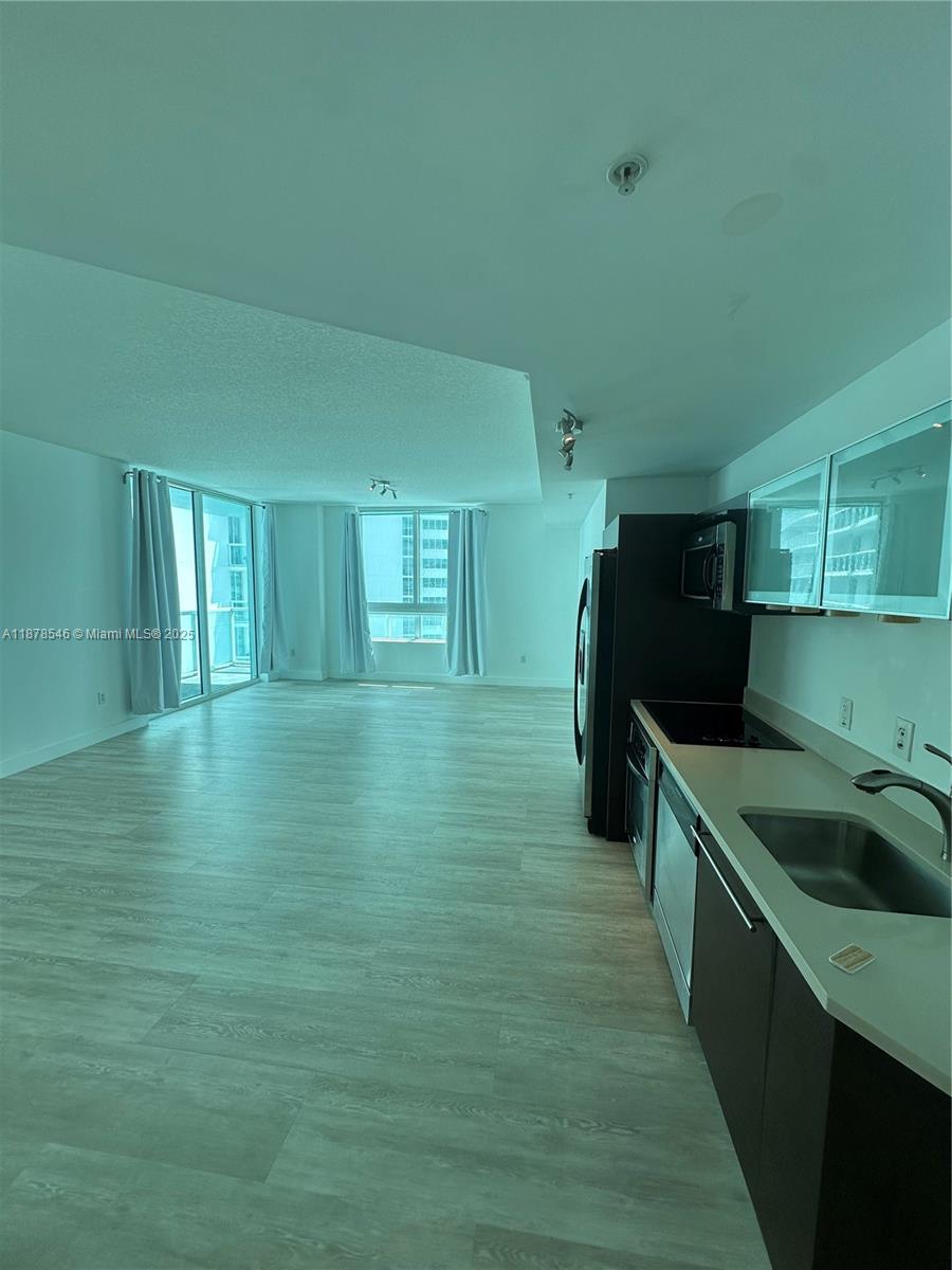 1900 North Bayshore Drive, Unit 2305 Miami, FL 33132 - Photo 4 of 13 a kitchen with a sink and refrigerator