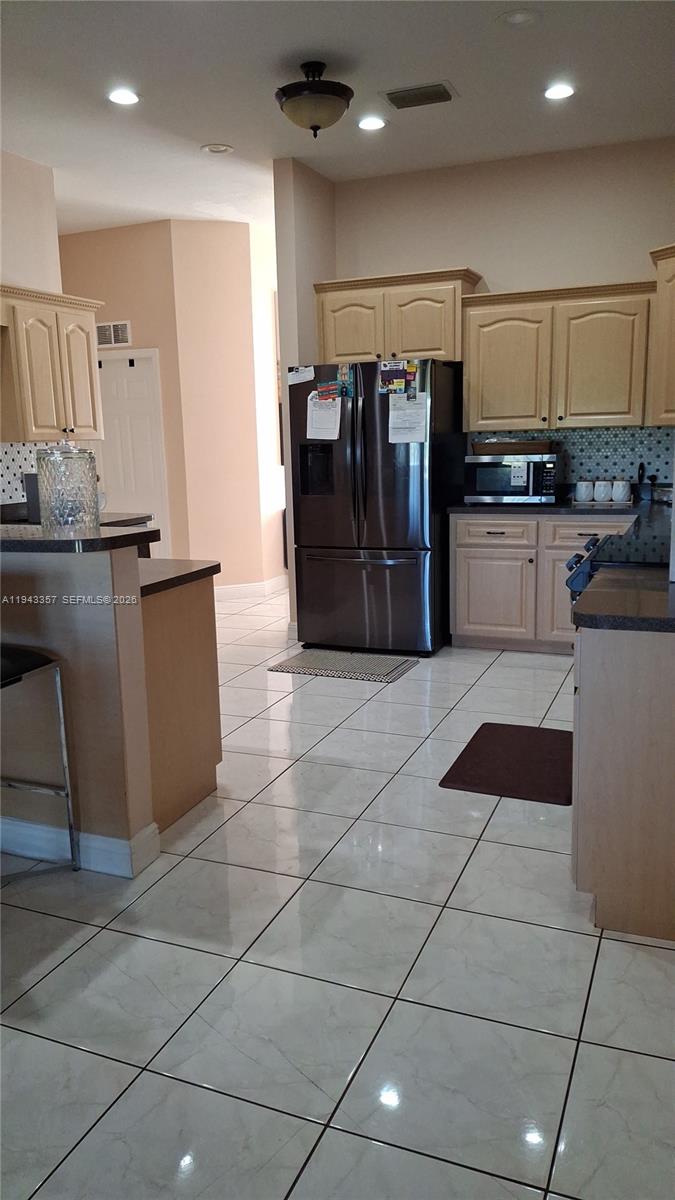 1034 Bayberry Loop Clewiston, FL 33440 - Photo 14 of 38 a kitchen with stainless steel appliances granite countertop a refrigerator and a stove