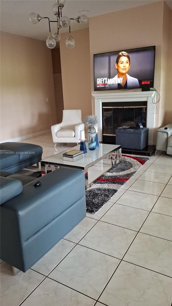 1034 Bayberry Loop Clewiston, FL 33440 - Photo 10 of 38 a living room with furniture a fireplace and a flat screen tv