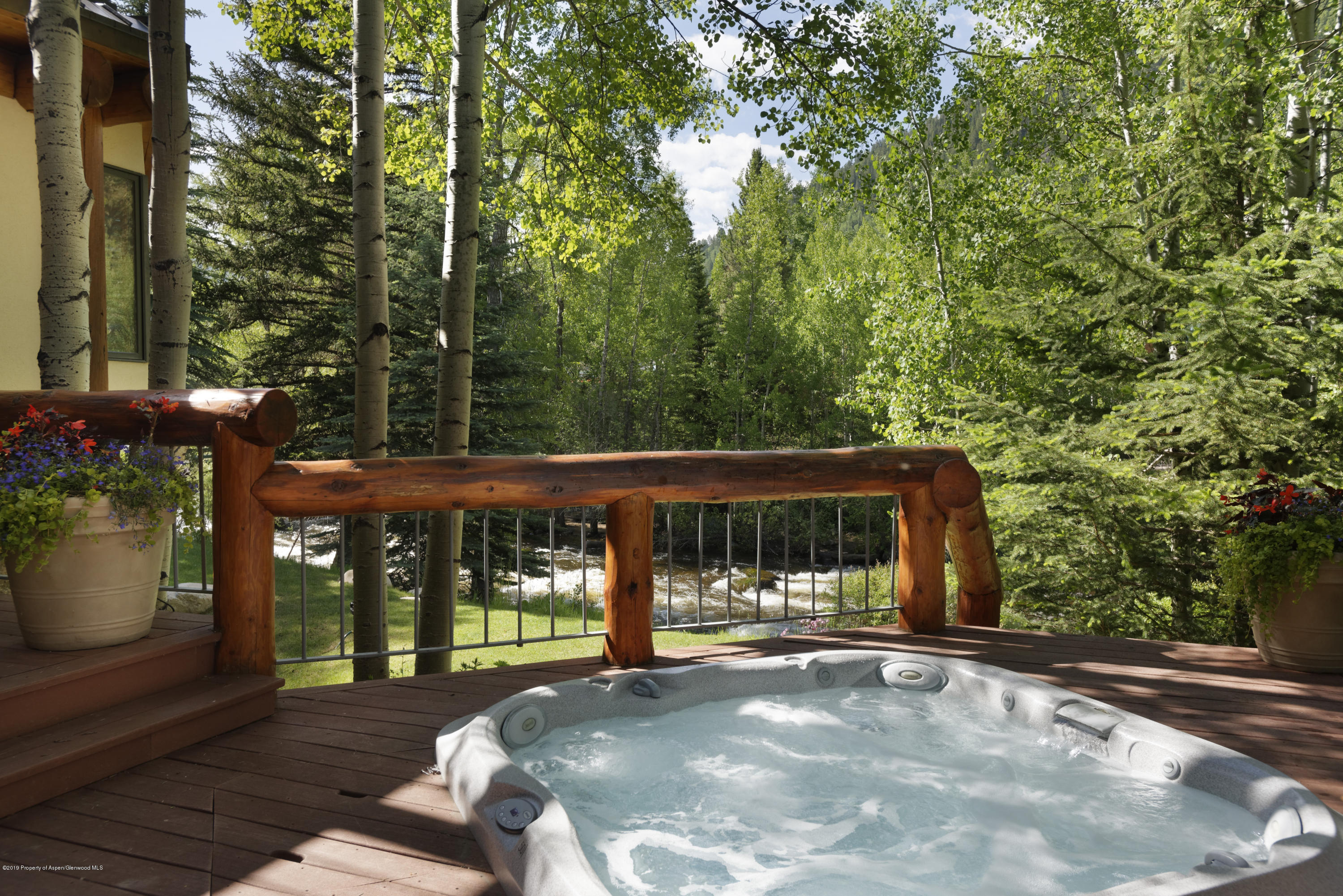 1417 Crystal Lake Road Aspen, CO 81611 - Photo 11 of 36 a view of a patio with table and chairs with wooden floor and fence