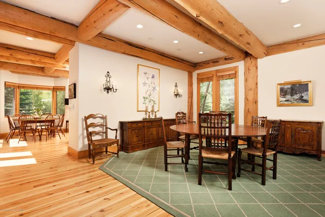 a dining hall with stainless steel appliances a dining table and chairs with wooden floor