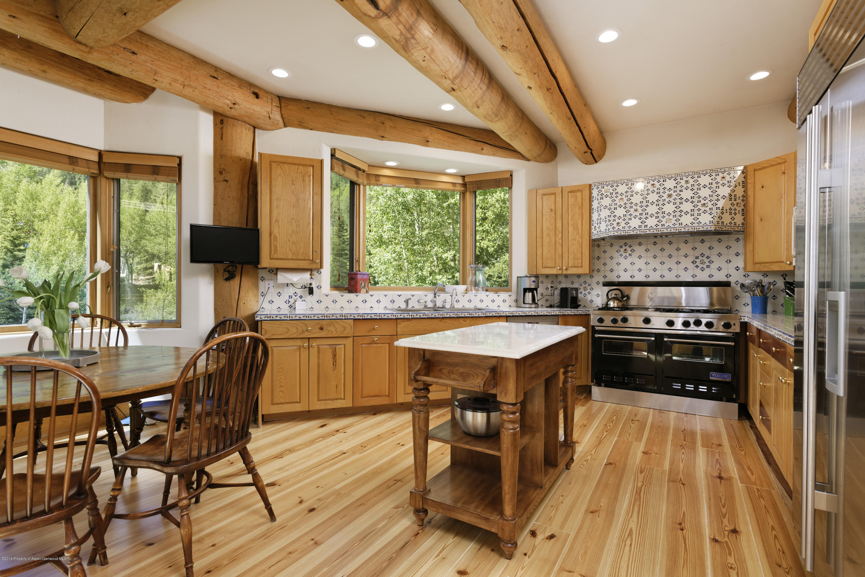 1417 Crystal Lake Road Aspen, CO 81611 - Photo 13 of 36 a kitchen with stainless steel appliances granite countertop a stove a refrigerator a kitchen island and chairs in it