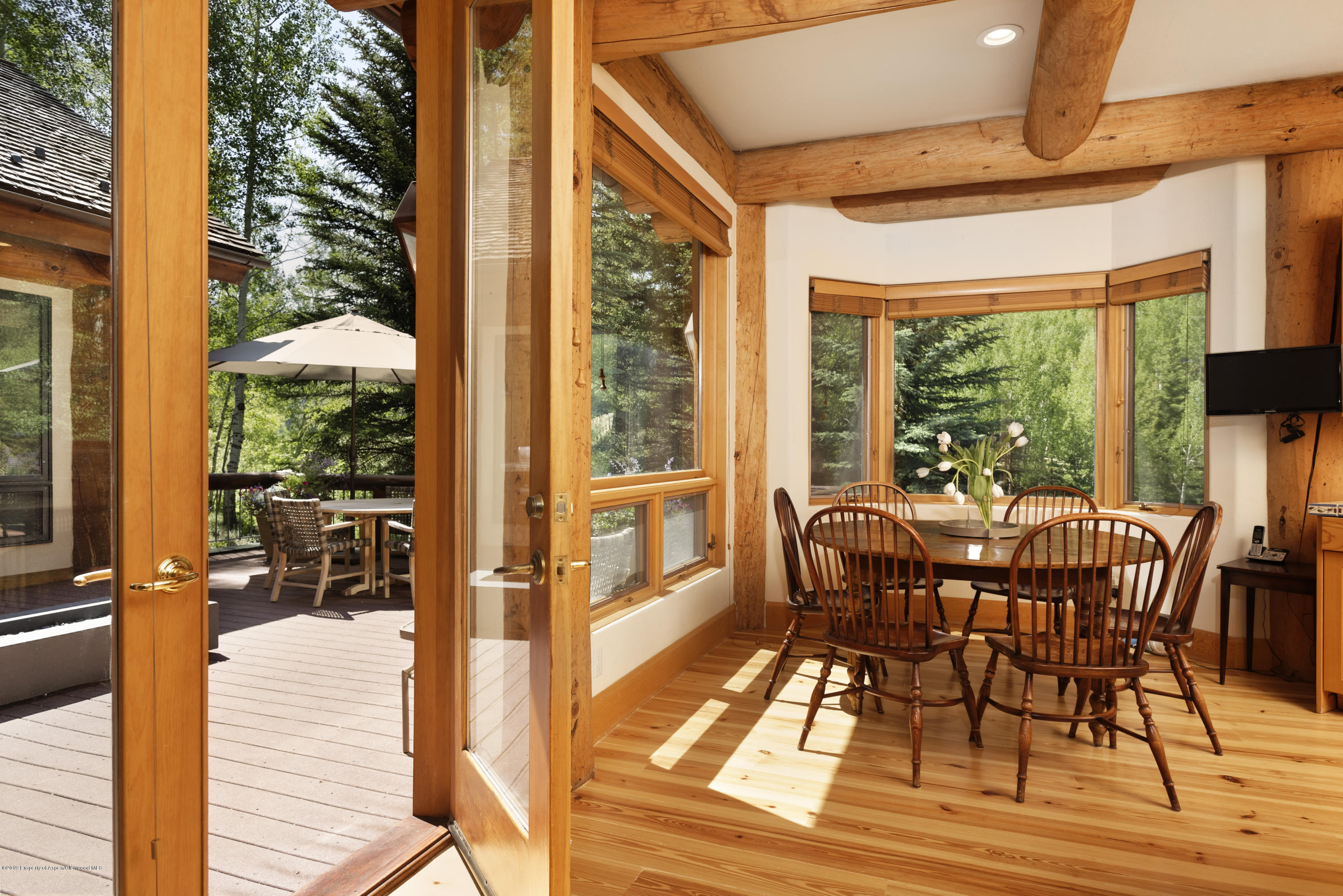 1417 Crystal Lake Road Aspen, CO 81611 - Photo 14 of 36 a view of a patio with table and chairs and wooden floor