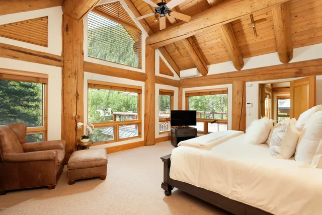 a bedroom with furniture and large windows