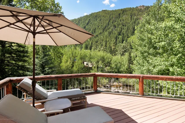 a view of a two chairs and table in the balcony