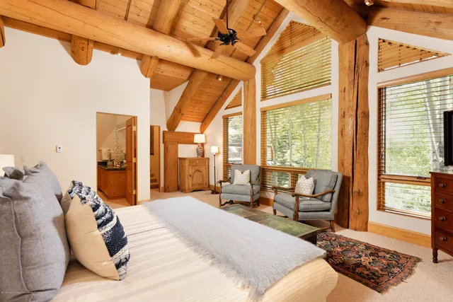 a large bedroom with a bed and large windows