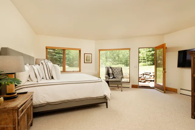 a bedroom with a bed and a flat tv screen on dresser