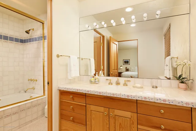 a bathroom with a granite countertop sink mirror and a shower