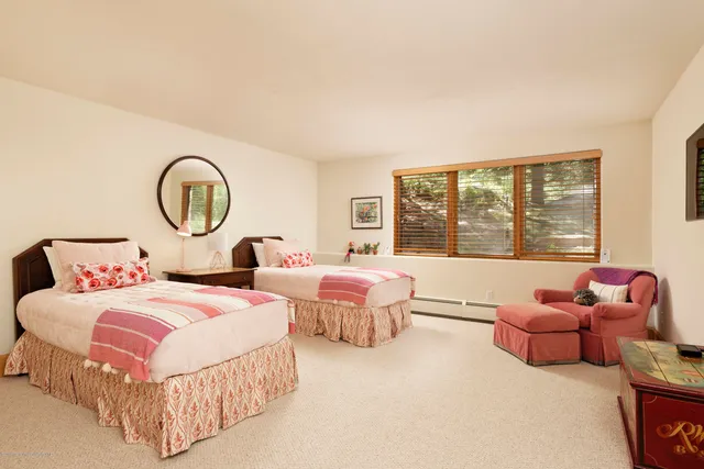 a bedroom with two beds and a large window