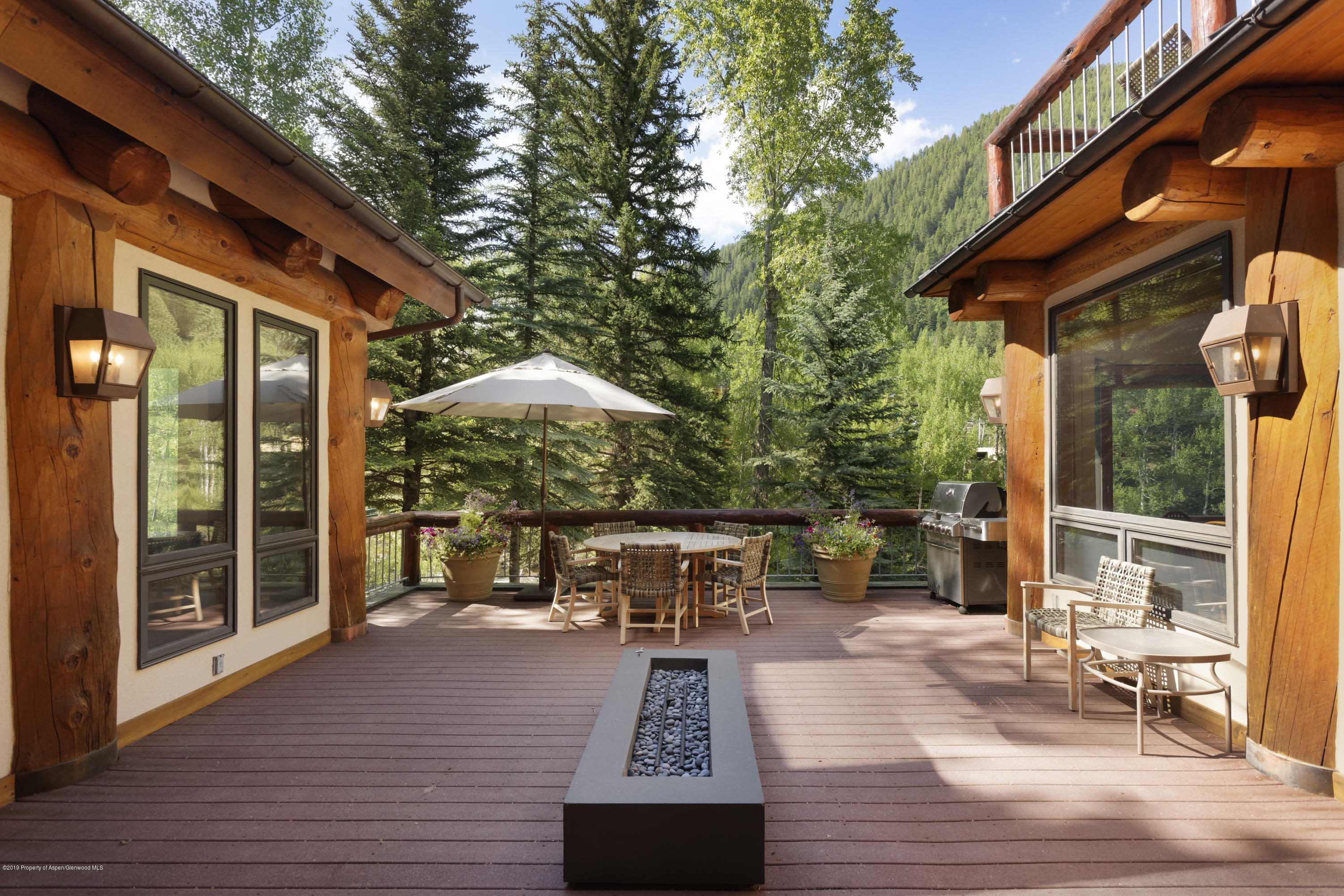 1417 Crystal Lake Road Aspen, CO 81611 - Photo 6 of 36 a view of a patio with table and chairs potted plants with wooden floor and fence