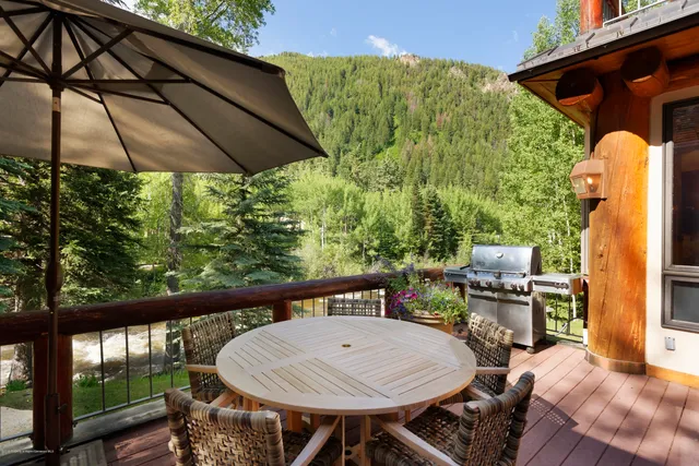 a roof deck with table and chairs under an umbrella