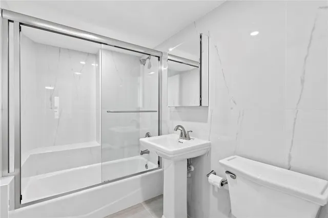 a bathroom with a sink mirror toilet and bathtub