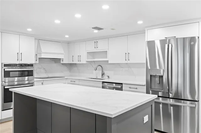 a kitchen with stainless steel appliances a sink and a refrigerator