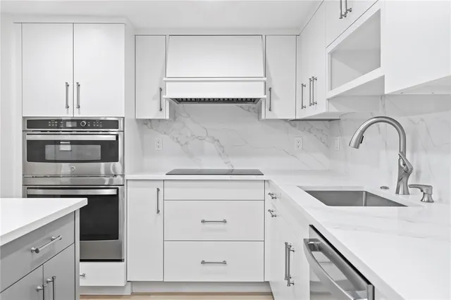 a kitchen with granite countertop white cabinets and appliances