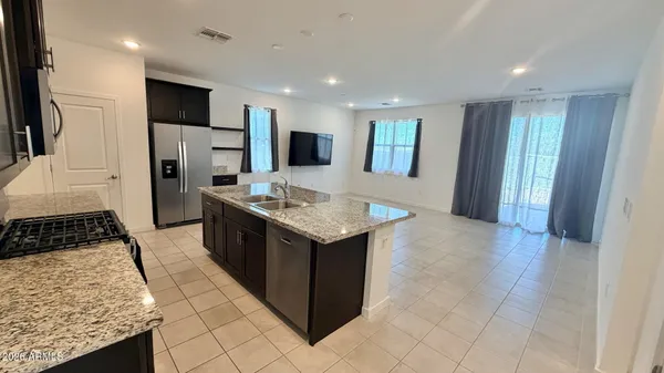 a kitchen with stainless steel appliances granite countertop a refrigerator and a stove top oven