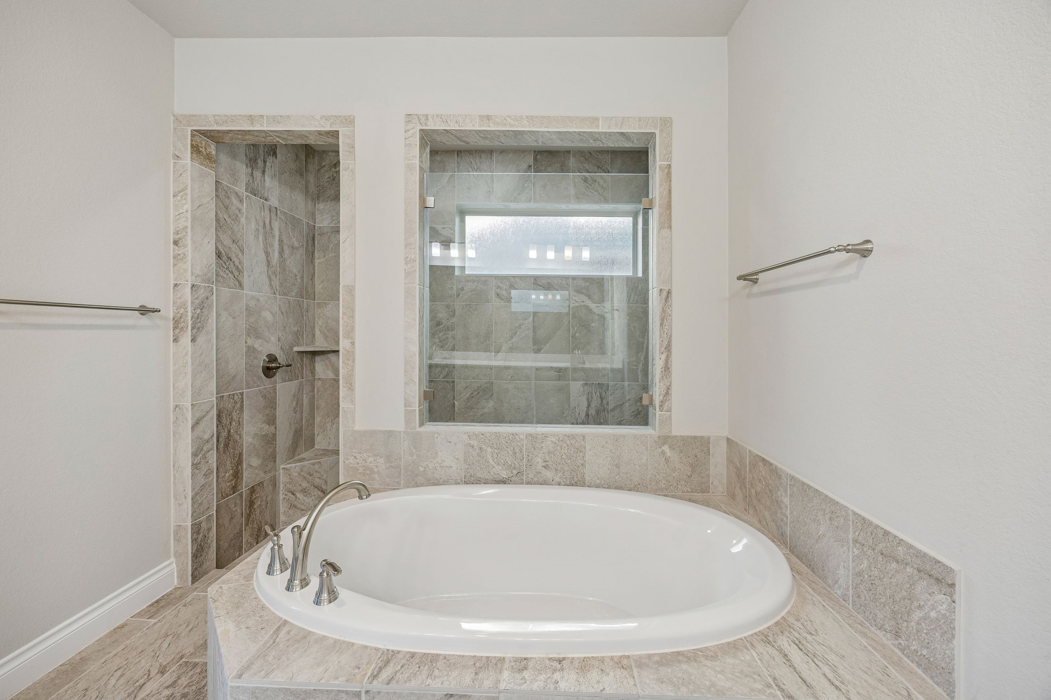 28706 Casen Ranch Lane Fulshear, TX 77441 - Photo 16 of 31 Relax in the deep soaking tub or the oversized frameless glass shower. High-end stone tile surrounds and a large frosted window provide both luxury and privacy for a true spa experience.