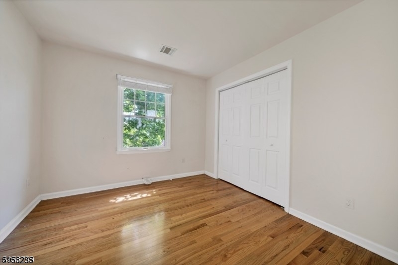 83 Springfield Avenue, Unit A Summit, NJ 07901 - Photo 7 of 14 an empty room with wooden floor and windows