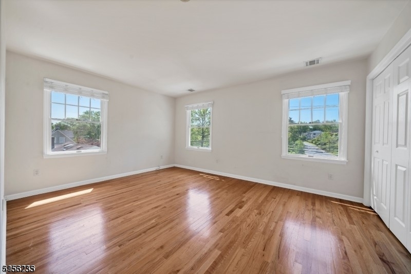 83 Springfield Avenue, Unit A Summit, NJ 07901 - Photo 8 of 14 a view of an empty room with wooden floor and a window