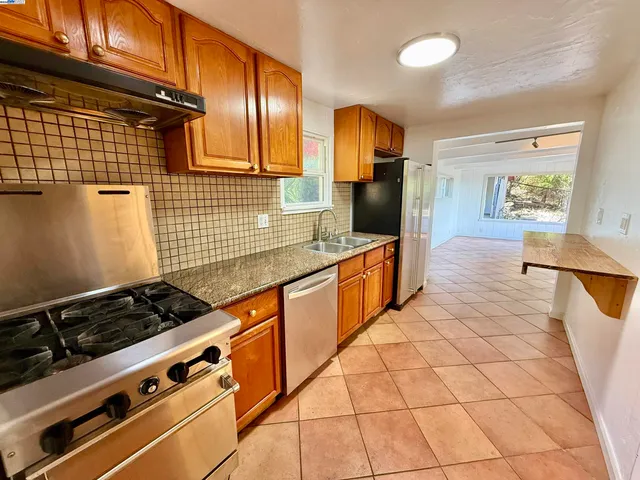 a kitchen with stainless steel appliances a stove a sink and a refrigerator