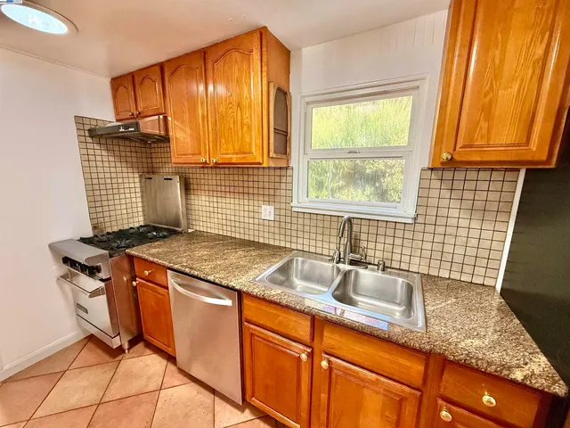 a kitchen with stainless steel appliances granite countertop sink stove top oven and cabinets