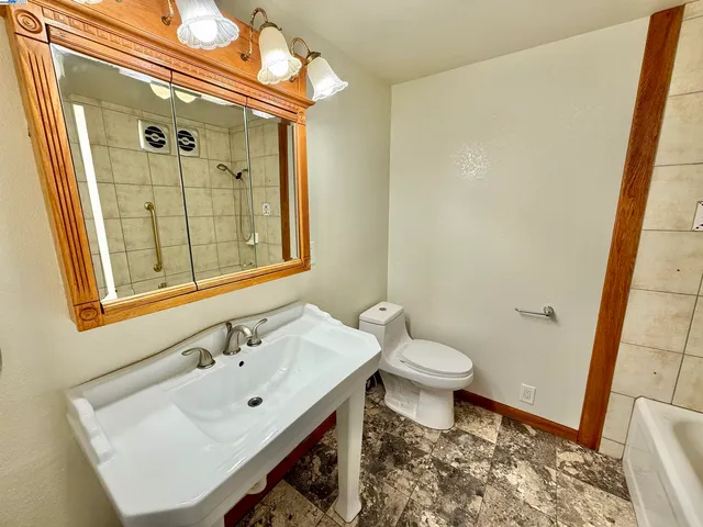 a bathroom with a sink a toilet and shower