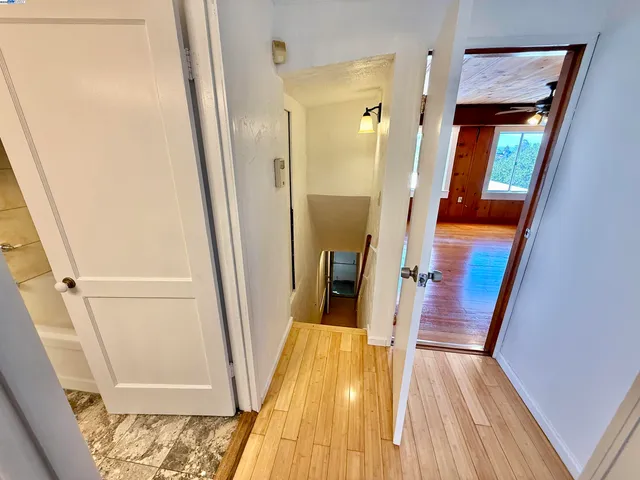 a view of a hallway view with wooden floor and staircase