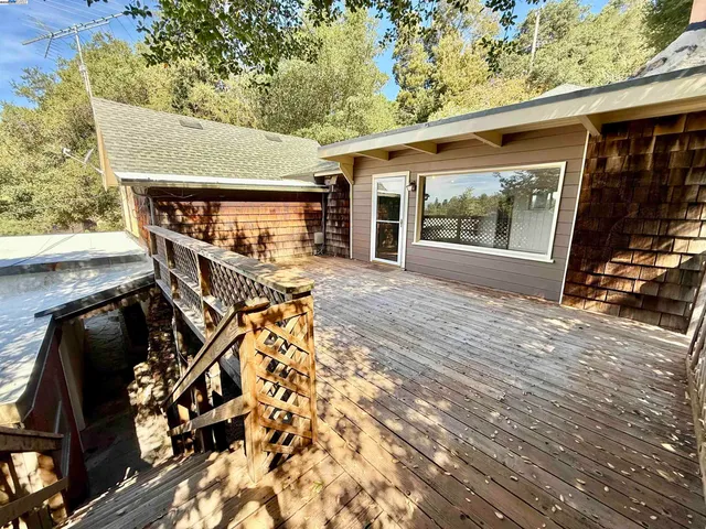 a roof deck with wooden floor and fence