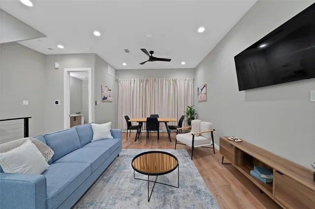 a living room with furniture a flat screen tv and kitchen view