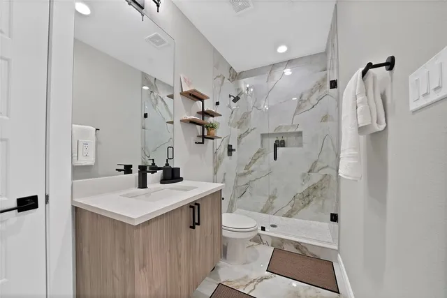 a bathroom with a sink vanity mirror and toilet
