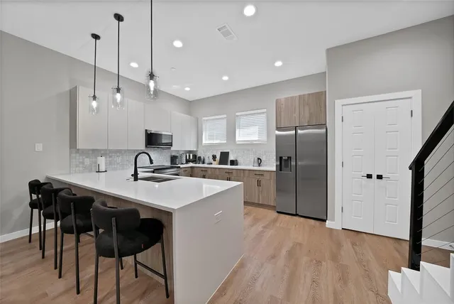 a kitchen with kitchen island a sink a counter and stainless steel appliances