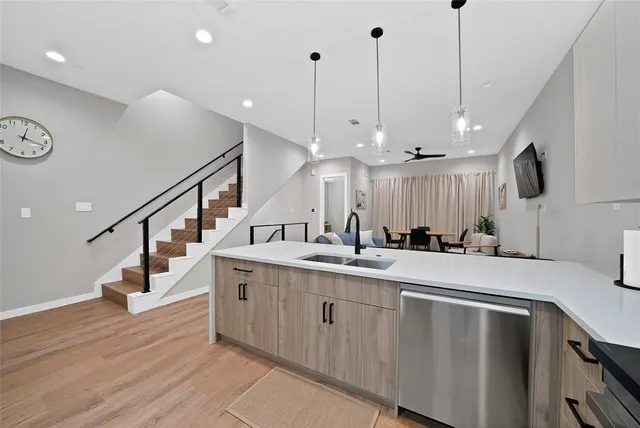 a large white kitchen with a large island oven a sink stainless steel appliances and cabinets