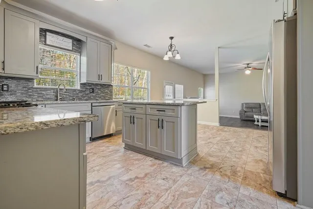 a kitchen with stainless steel appliances granite countertop a refrigerator and a sink