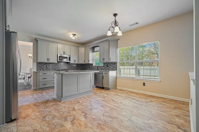 a kitchen with stainless steel appliances granite countertop a refrigerator and a stove