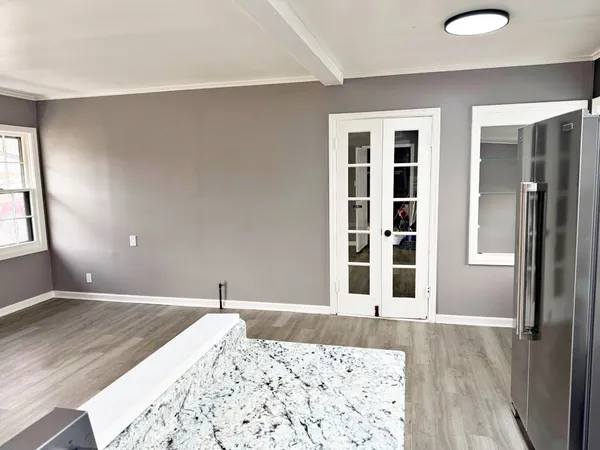 a view of a bedroom with wooden floor and windows