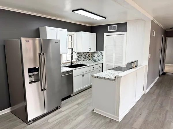 a kitchen with a refrigerator sink and stove