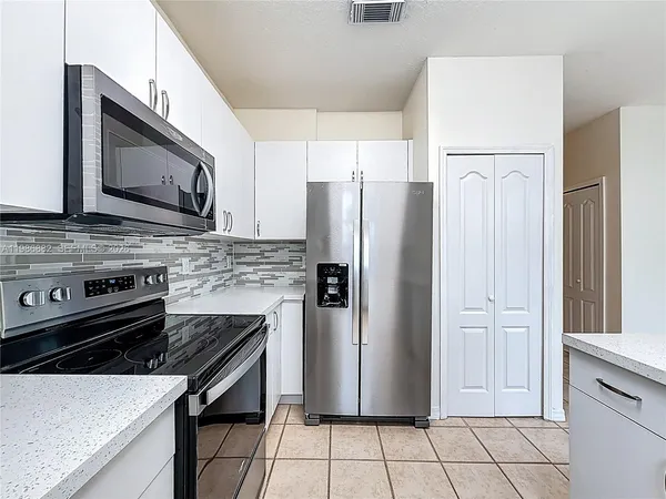 a kitchen with stainless steel appliances granite countertop a refrigerator stove and sink